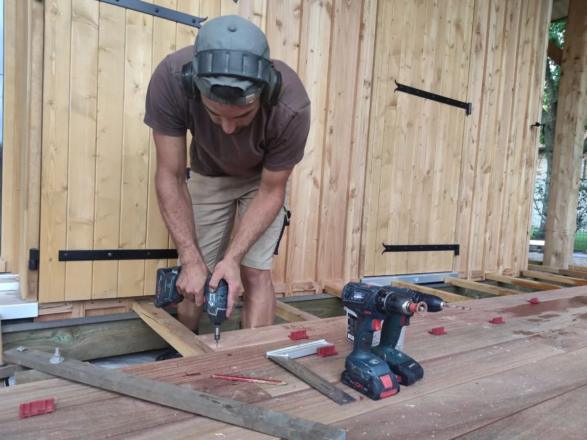 Pierre au travail, posant les lames d’une terrasse en bois